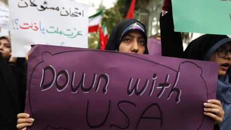 Iranian women carry anti-US signs during a demonstration outside the former US embassy in Tehran © ATTA KENARE