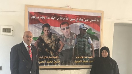 Mohammed Gabbash Al Hamid and his wife Fatima next to the photo of their martyrd sons in the SAA, Ahmed and Hussain. © Vanessa Beeley