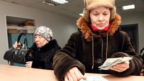 A woman counts the pension she received at a post-office in Chita © Evgeny Yepanchintsev