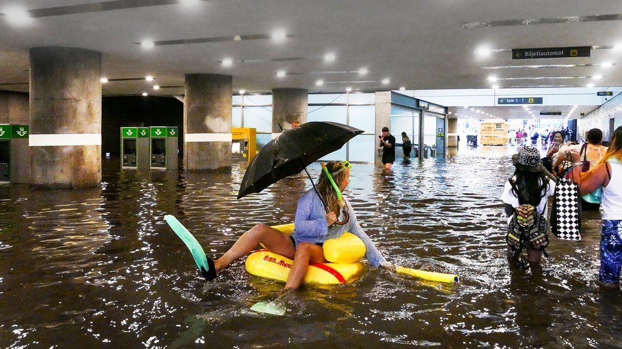 Flooded train station? Just swim on ducky float and ignore traffic chaos (VIDEOS)