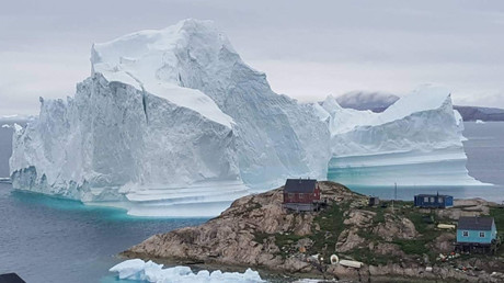 A giant iceberg towers over the village of Innaarsuit, Greenland © Ritzau Scanpix Denmark