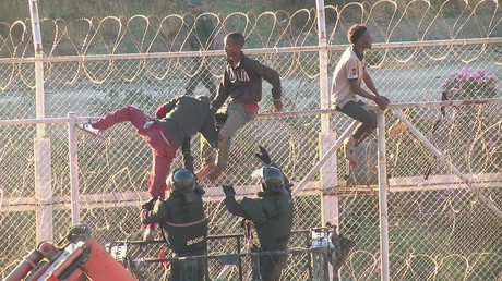 African migrants in this still image from video climb the border from Morocco to Spain's North African enclave of Ceuta, Spain, July 26, 2018