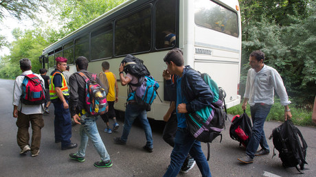 Illegal immigrants get on a bus under police custody in Hungary. © Global Look Press/ Attila Volgyi