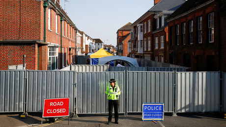 A police officer stands in front of screening erected behind John Baker House, Britain, July 5, 2018 © Henry Nicholls / Reuters
