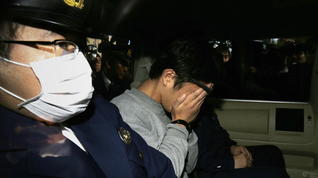 File photo: Takahiro Shiraishi (C) covers his face with his hands, Tokyo on November 1, 2017. © STR / JIJI PRESS / AFP