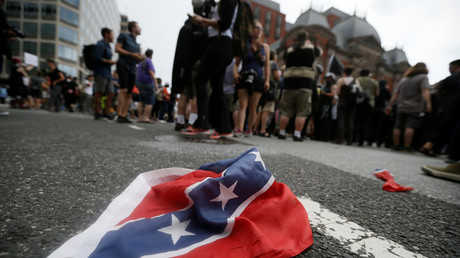 A ripped Confederate flag lies next to a group of left-wing Antifa protesters in Charlottesville, Virginia © Jim Bourg