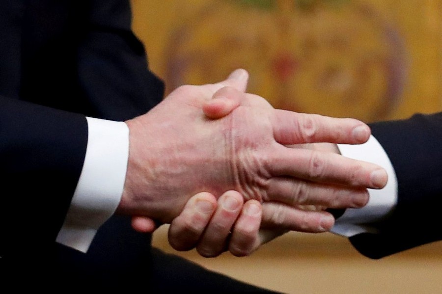 Emmanuel Macron shakes Donald Trump‘s hand as they meet on Staurday