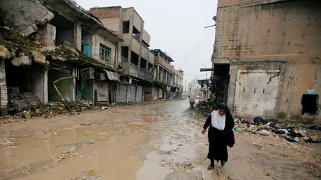 A Woman walks next to ruins in the Old City of Mosul © Reuters / Khalid al-Mousily