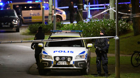 Officers standing next to police vehicles in Rosengard, Malmo © TT News Agency via REUTERS/Johan Nilsson