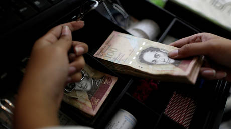 FILE PHOTO: A cashier counts Venezuelan bolivar notes © Reuters / Ueslei Marcelino 