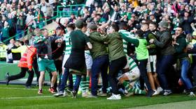 Celtic fan invades pitch with TODDLER in arms during fiery Old Firm clash   