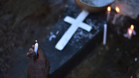 A voodoo devotee holds a candle while participating in ceremonies honoring the  voodoo spirit © AFP / Hector Retamal 