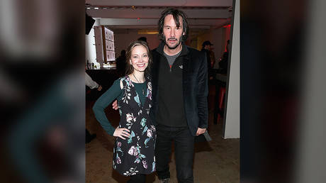 Keanu Reeves doing the "hover hand" with actress Rebekah Kennedy. ©  Getty Images/ Phillip Faraone