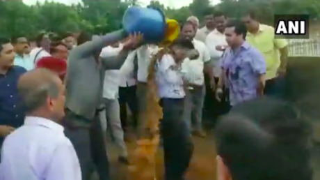 Indian politician & supporters drench engineer with mud in road protest (VIDEO)