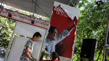 A worker dismantles a booth with a poster of outgoing Greek Prime Minister Alexis Tsipras ©REUTERS/Alkis Konstantinidis