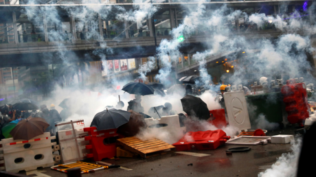 Demonstrators stand behind barricades, surrounded by tear gas, during a protest in Tsuen Wan, in Hong Kong, China, August 25, 2019. © REUTERS/Kai Pfaffenbach