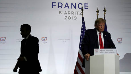 French President Emmanuel Macron leaves as U.S. President Donald Trump looks on after a joint news conference at the end of the G7 summit in Biarritz, France, August 26, 2019. © REUTERS/Carlos Barria