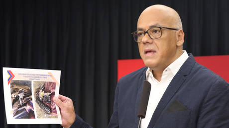 Venezuela's Communications and Information Minister Jorge Rodriguez holds an image of a "terrorist compound" in Colombia © Miraflores Palace/Handout via REUTERS