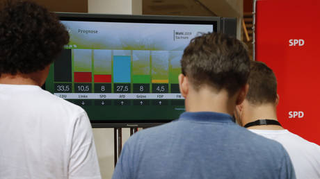 Journalists watch first exit polls following the regional state elections in Saxony and Brandenburg in Berlin