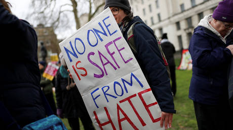 A protestor holds a placard as she takes part in an anti-racism march in London, Britain March 16, 2019. © REUTERS/Simon Dawson