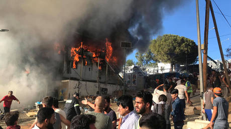 Rioting migrants attack firefighters & police as blaze rages in Lesbos refugee camp, 2 killed (VIDEO)