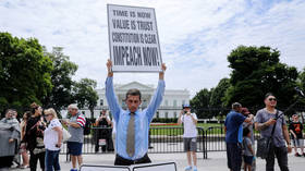 Steve Swanson protests in silence with a sign over his head reading “Impeach Now!” in front of the White House in Washington, U.S. June 19, 2019. © REUTERS/Jonathan Ernst
