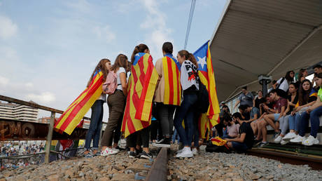 People carry and wear Esteladas (Catalan separatist flag) during a protest after a verdict in a trial over a banned independence referendum, in Girona, Spain, October 14, 2019 © Reuters / Juan Medina