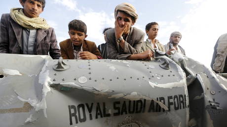 FILE PHOTO. People in Yemen stand by part of a downed Saudi fighter jet. ©REUTERS / Khaled Abdullah