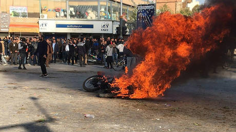 Iranian protesters gather around a burning motorcycle during a demonstration against an increase in gasoline prices in the central city of Isfahan, on November 16, 2019. © AFP