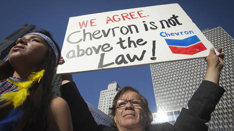 FILE PHOTO: A protester demonstrates against Chevron's racketeering lawsuit in New York, 2013 © Reuters / Carlo Allegri