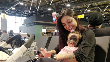 Carol Fenner holds her daughter Luna upon their arrival at Moscow's Sheremetyevo airport, Russia September 25, 2019. Carol transports her six-month-old daughter to Russia's Krasnodar Region from the U.S. state of Florida for therapy to cure Luna's rare skin condition. © REUTERS/Dmitry Turlyun