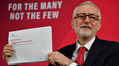 Labour party leader Jeremy Corbyn holds up a document during a press conference in London © AFP / Ben Stansall