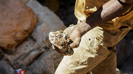 An artisanal miner carries raw ore at Tilwizembe, a former industrial copper-cobalt mine, outside of Kolwezi, the capital city of Lualaba Province in the south of the Democratic Republic of the Congo © REUTERS/Kenny Katombe
