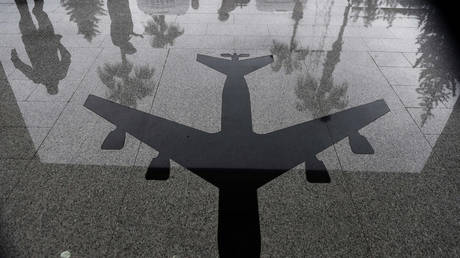 People reflect on a floor with an airplane symbol at the air base in Incirlik