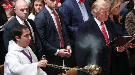 FILE PHOTO: An incense-bearer passes by President Donald Trump and the first lady at a Christmas Eve church service at the National Cathedral in Washington.