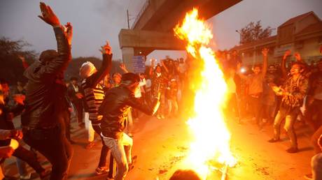 Protesters burn an effigy depicting PM Narendra Modi