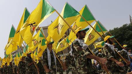 Kataib Hezbollah members wave the party's flags during a parade in Baghdad. © Reuters / Thaier al-Sudani