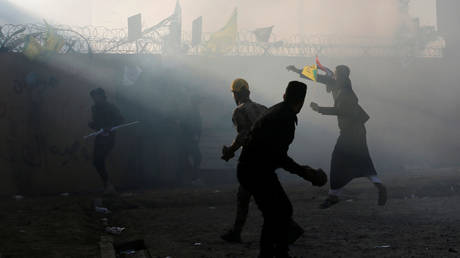 Protesters throw stones at the US embassy in Baghdad © Reuters / Wissm al-Okily