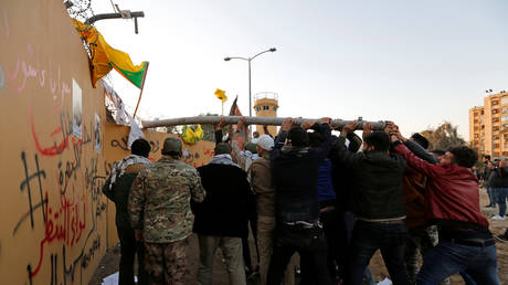 Protesters and militia fighters attack the U.S. Embassy during a protest to condemn air strikes on bases belonging to Hashd al-Shaabi (paramilitary forces), in Baghdad, Iraq December 31, 2019. © REUTERS/Wissm al-Okili