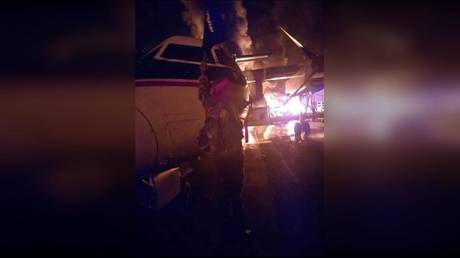 An image distributed by al-Shabaab shows a militant next to a burning aircraft, said to be at the Manda Bay Airfield.