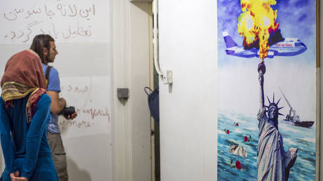 PHILE PHOTO: Tourists walk past a poster remembering the Iran Air flight 655 which was shot down by United States Navy in 1988