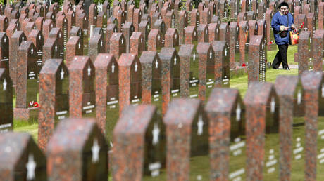 FILE PHOTO: An elderly woman visits a military cemetery in Moscow where numerous veterans of World War II are buried.