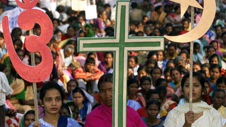 FILE PHOTO: Indian women hold symbols of Hinduism, Christianity and Islam during a peace rally in the eastern Indian city of Calcutta