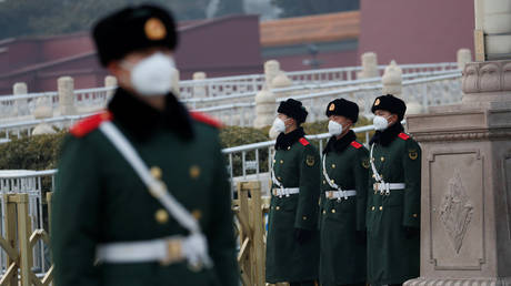 Paramilitary officers wearing face masks stand guard at the Tiananmen Gate in Beijing, as the country is hit by an outbreak of coronavirus