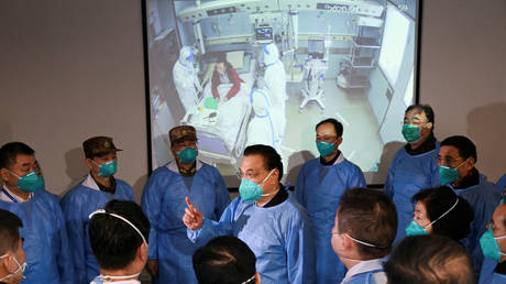 Chinese Premier Li Keqiang wearing a mask and protective suit speaks to medical workers as he visits the Jinyintan hospital where the patients of the new coronavirus are being treated following the outbreak, in Wuhan, Hubei province, China January 27, 2020. © REUTERS / cnsphoto