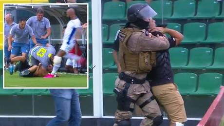 Footballer tries to kick fan in the HEAD but injures teammate during pitch invasion in Brazil (VIDEO)