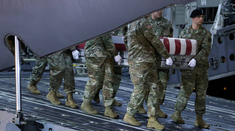 An honor guard carries the transfer case holding the remains of US Army soldiers killed in eastern Afghanistan, Dover Air Force Base, Delaware, February 10, 2020.