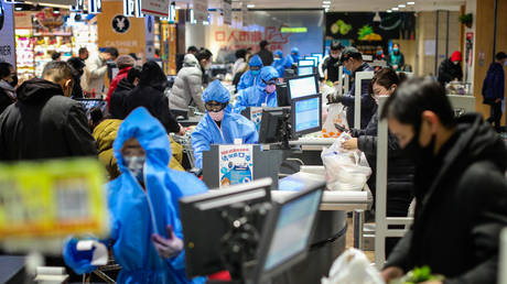 People wearing protective masks shop at a supermarket © AFP / STR