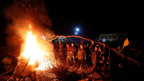 Demonstrators set fire and erect a barricade as they protest the arrival of a plane carrying evacuees from China in the village of Novi Sanzhary, Ukraine, on February 20, 2020.