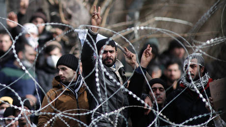 Migrants and refugees behind a wired fence at the borderline between Greece and Turkey near the closed Kastanies border crossing in northeastern Greece, March 2, 2020 © Global Look Press / Dimitris Tosidis / Xinhua